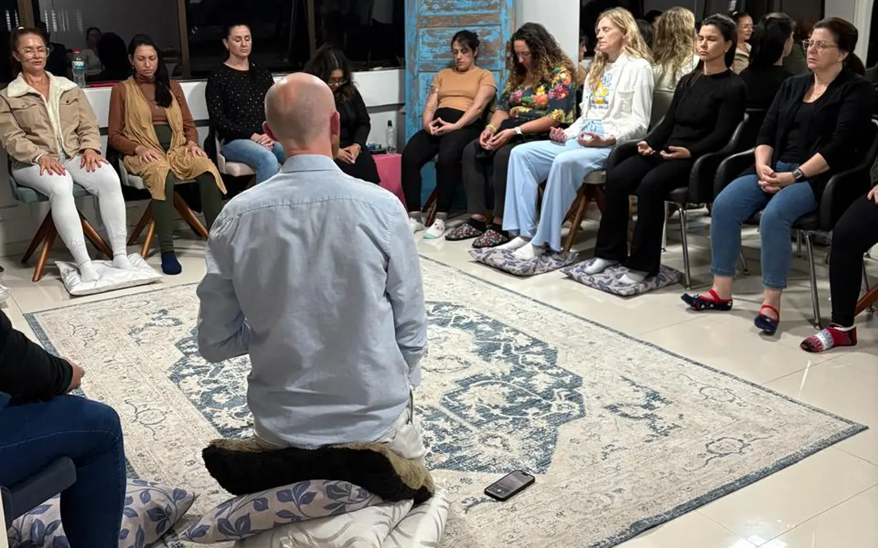 Grupo em meditação, sentado em círculo com Milton conduzindo à frente